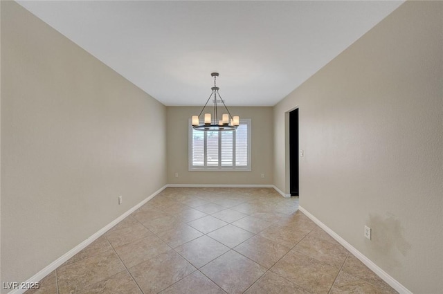 tiled spare room with a notable chandelier