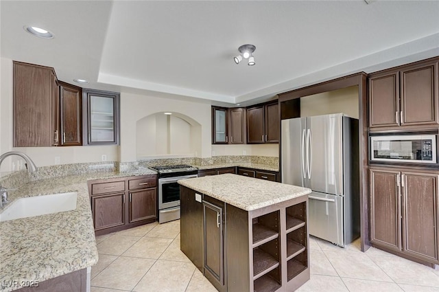 kitchen featuring sink, a kitchen island, stainless steel appliances, and dark brown cabinets