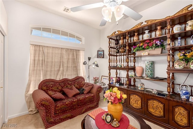 living area featuring ceiling fan and light colored carpet