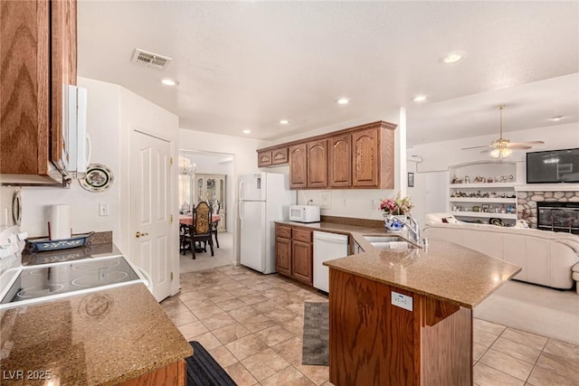 kitchen with white appliances, sink, ceiling fan, built in features, and kitchen peninsula