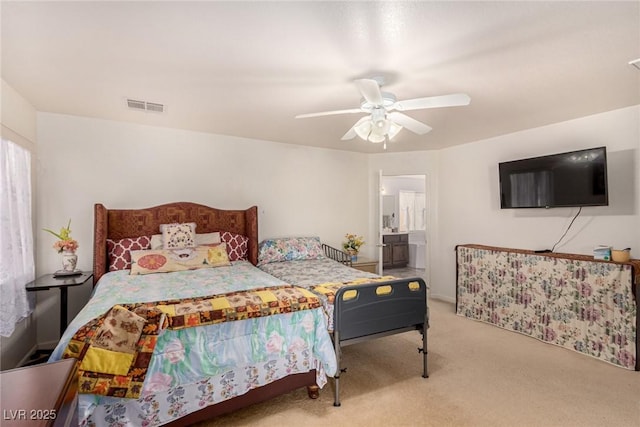 carpeted bedroom with ensuite bathroom and ceiling fan