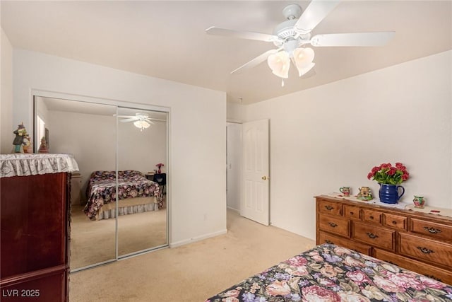 bedroom featuring ceiling fan, light carpet, and a closet