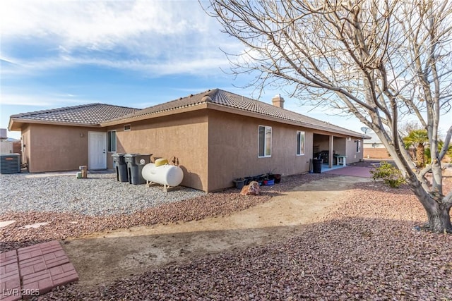 rear view of house featuring central AC unit and a patio area