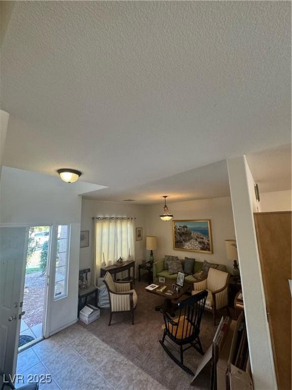 tiled living room featuring a textured ceiling