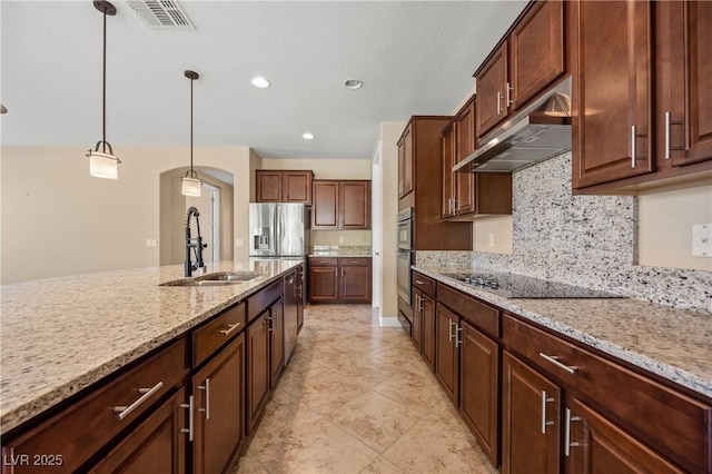 kitchen with sink, hanging light fixtures, stainless steel appliances, tasteful backsplash, and light stone counters