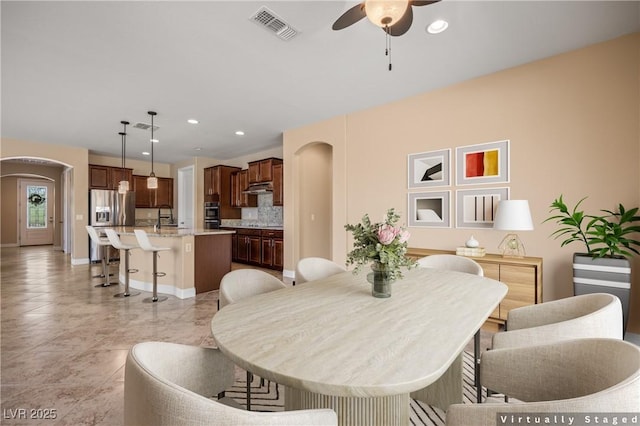 dining area with ceiling fan and sink