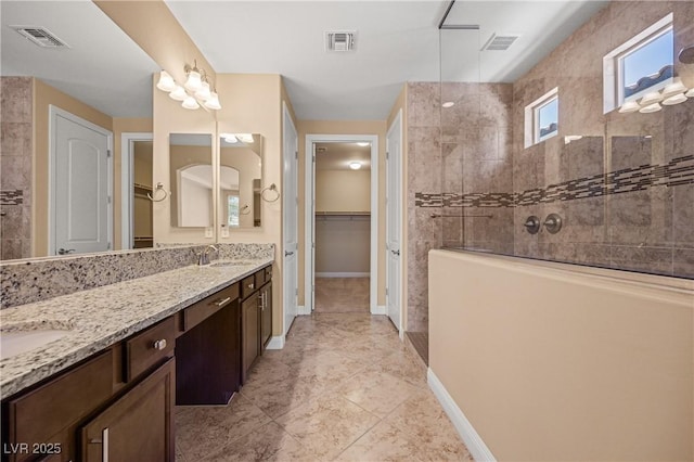 bathroom featuring vanity and tiled shower