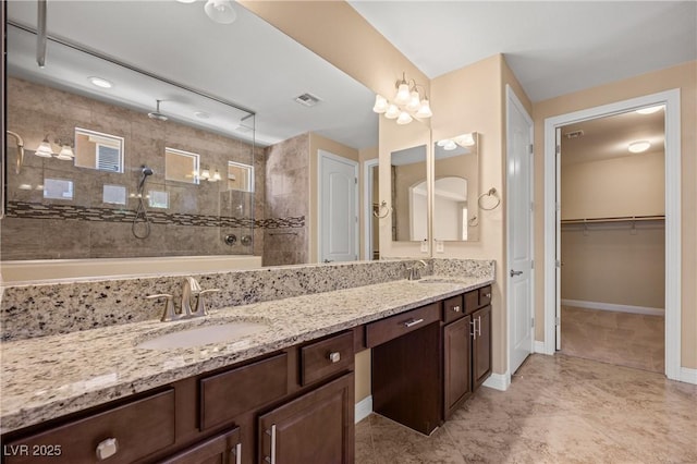 bathroom with vanity and a tile shower