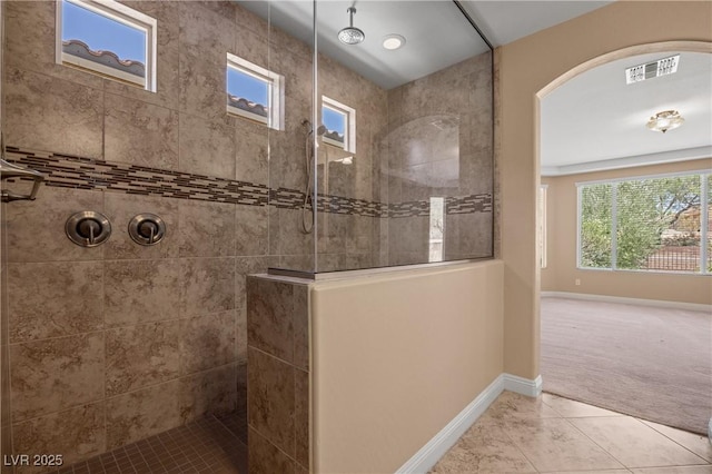 bathroom with tile patterned flooring and tiled shower