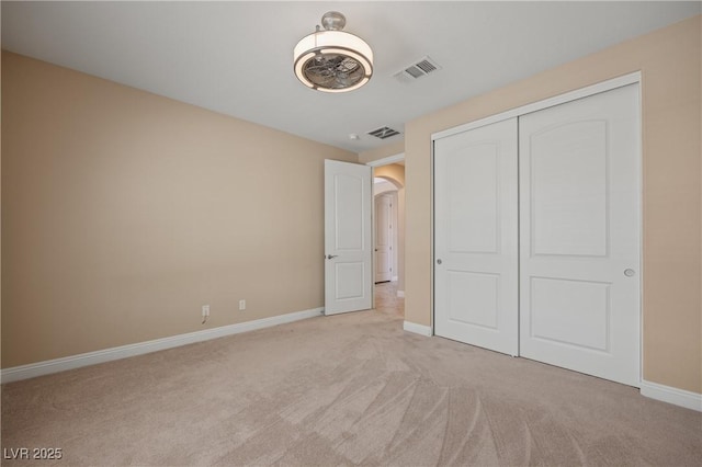 unfurnished bedroom with light carpet and a closet