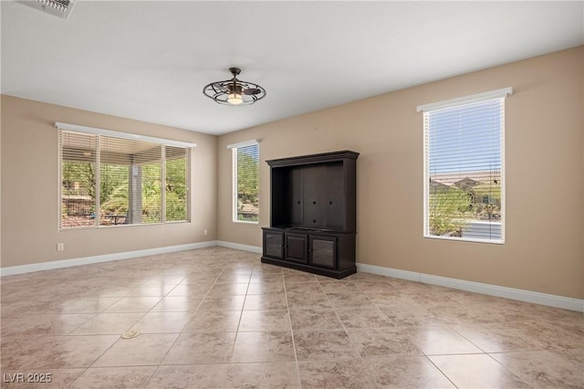 tiled empty room featuring ceiling fan