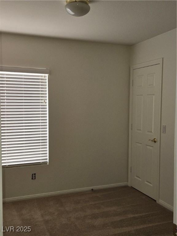 empty room with dark colored carpet