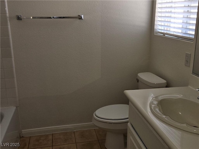 bathroom with toilet, vanity, and tile patterned floors