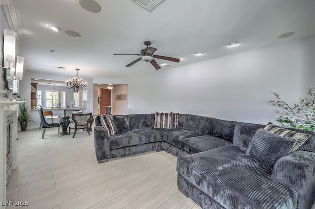 living room featuring ceiling fan with notable chandelier