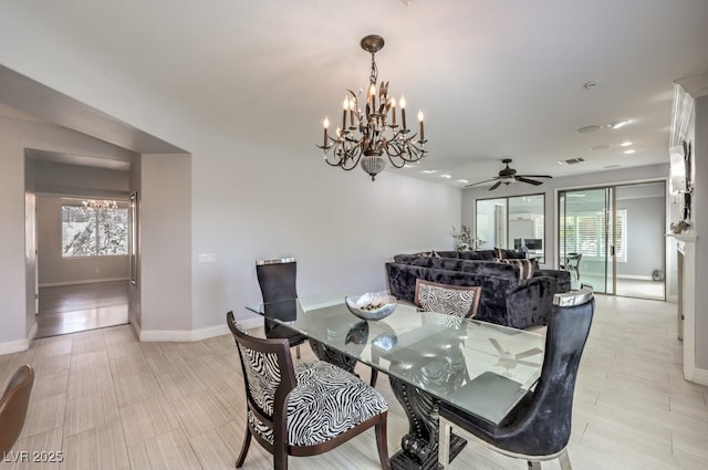 dining area featuring ceiling fan with notable chandelier