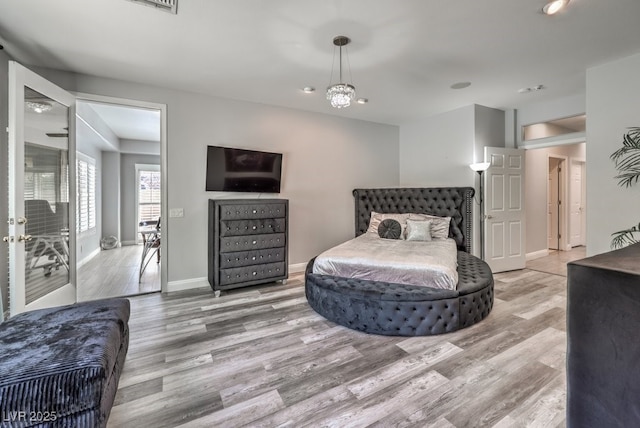 bedroom with light hardwood / wood-style flooring and a notable chandelier