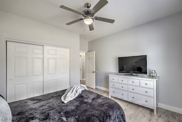 bedroom with a closet, light hardwood / wood-style flooring, and ceiling fan