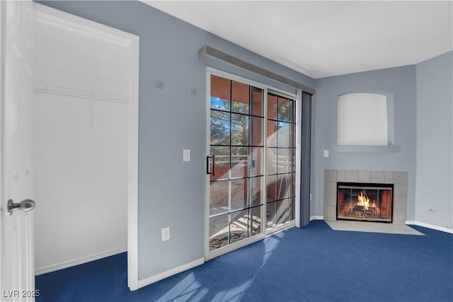 unfurnished living room with a tiled fireplace and carpet