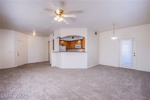 unfurnished living room featuring light colored carpet and ceiling fan