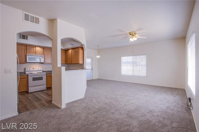 kitchen featuring dark colored carpet, ceiling fan, pendant lighting, and white appliances