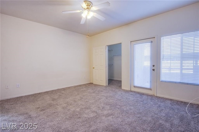 unfurnished bedroom featuring ceiling fan, carpet flooring, and a spacious closet