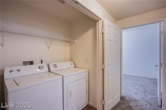 laundry area with washing machine and clothes dryer and dark colored carpet