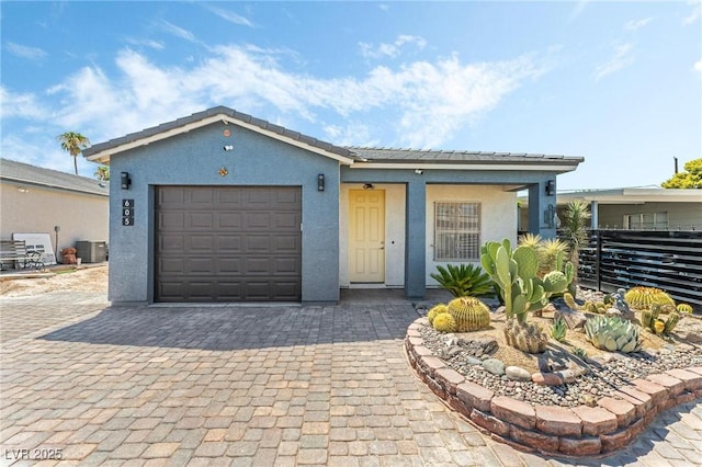 single story home featuring a garage and central air condition unit