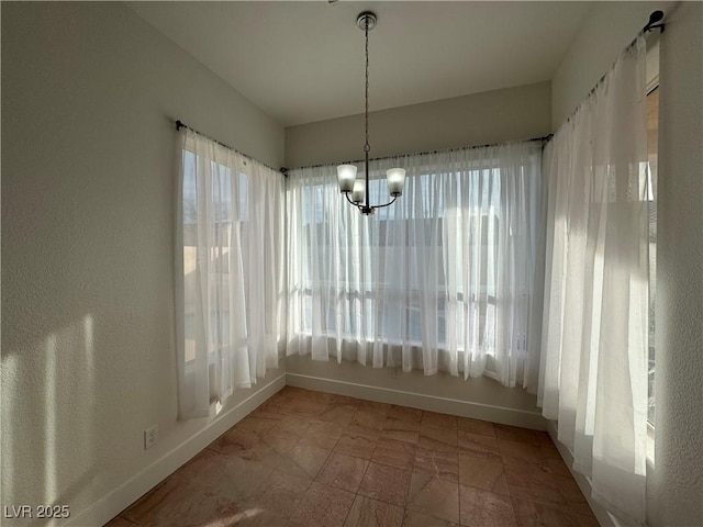 unfurnished dining area with a healthy amount of sunlight and an inviting chandelier