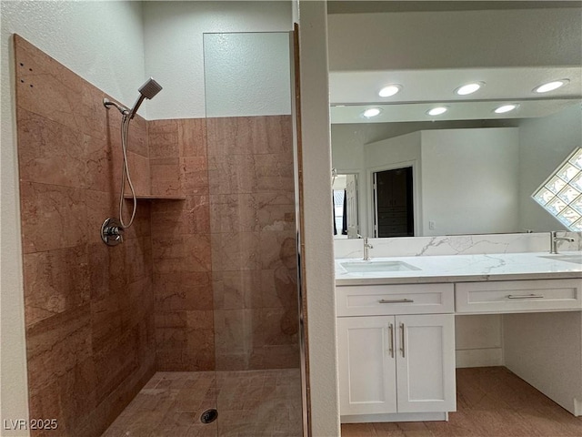 bathroom with vanity and a tile shower