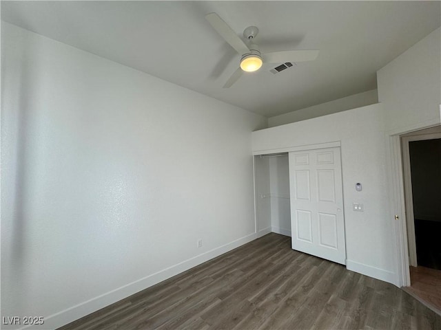 unfurnished bedroom featuring a closet, dark wood-type flooring, and ceiling fan