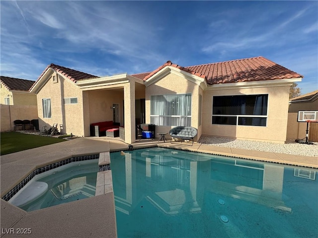 rear view of house featuring a patio area and a swimming pool with hot tub