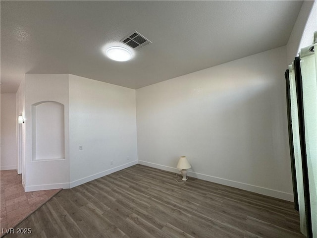 empty room with dark hardwood / wood-style flooring