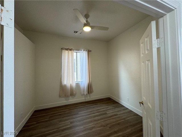 empty room featuring ceiling fan and dark wood-type flooring