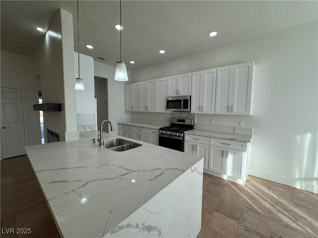 kitchen with light stone counters, white cabinets, pendant lighting, and appliances with stainless steel finishes