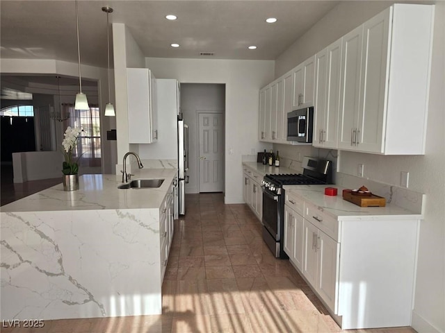 kitchen featuring pendant lighting, white cabinets, sink, appliances with stainless steel finishes, and light stone counters