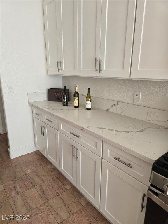 bar with light stone counters and white cabinets