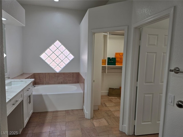 bathroom with vanity and a bath