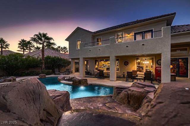 pool at dusk with a patio