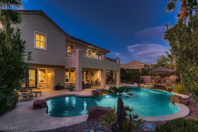 pool at dusk with a patio