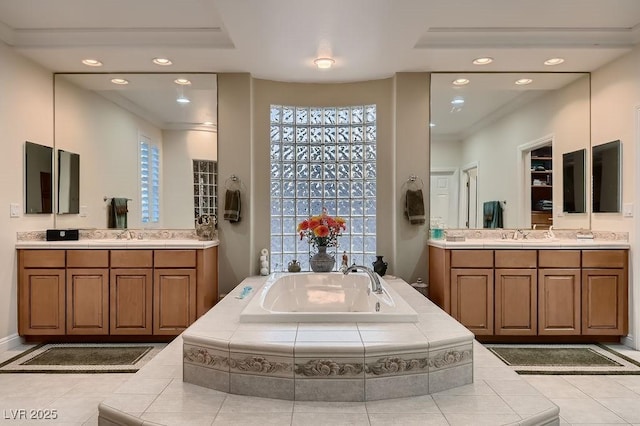 bathroom with vanity, tiled bath, and tile patterned flooring