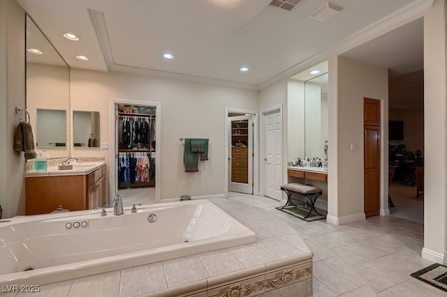 bathroom with tile patterned flooring, vanity, and tiled bath