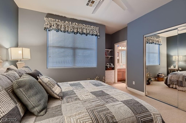 bedroom featuring ceiling fan, ensuite bathroom, carpet flooring, and a closet