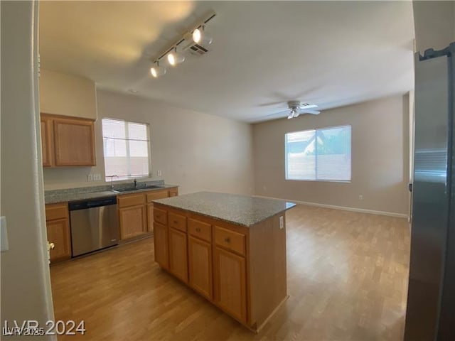 kitchen with ceiling fan, dishwasher, a center island, sink, and light wood-type flooring