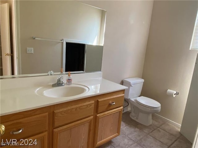 bathroom with tile patterned flooring, vanity, and toilet