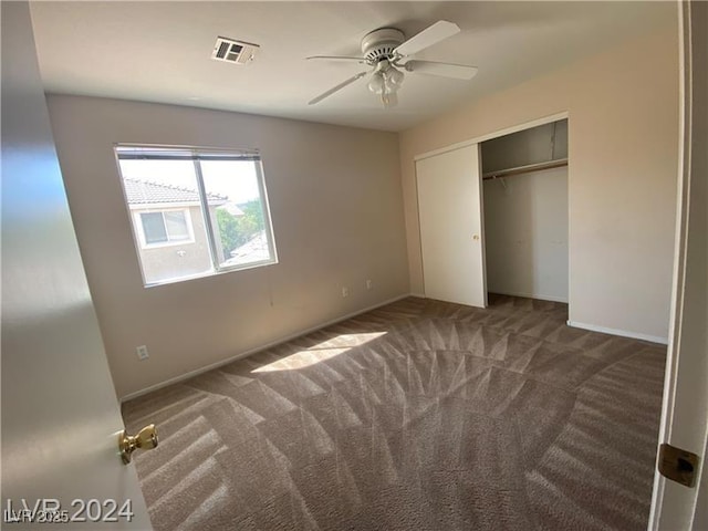 unfurnished bedroom featuring ceiling fan, a closet, and dark carpet