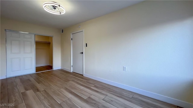 unfurnished bedroom featuring a closet and light wood-type flooring