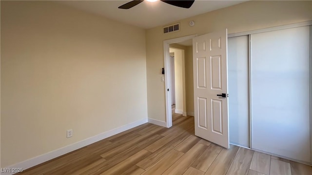 unfurnished bedroom with light hardwood / wood-style floors, a closet, and ceiling fan