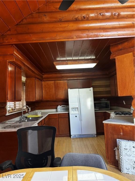 kitchen with sink, wooden ceiling, white refrigerator with ice dispenser, vaulted ceiling, and range