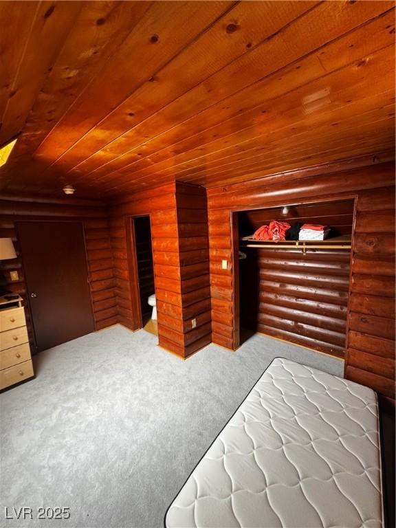 carpeted bedroom with wooden ceiling, log walls, and a closet