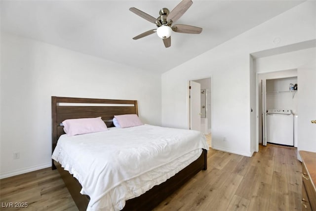 bedroom featuring ensuite bath, ceiling fan, hardwood / wood-style flooring, washer / clothes dryer, and lofted ceiling